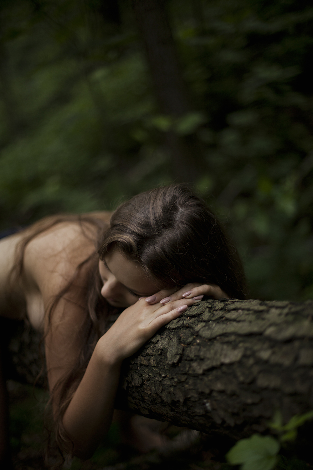 Naga kobieta przytula się do drzewa